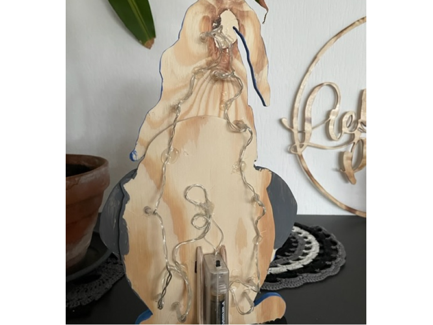 Holzpinguin mit Lichterkette von hinten