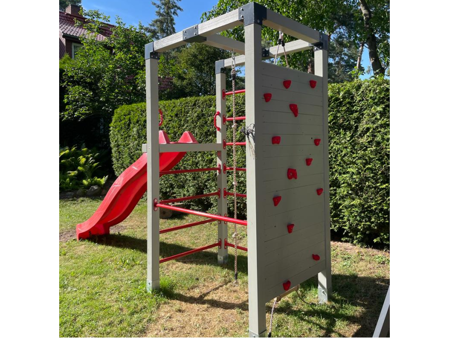 Ein Spielturm mit Kletterwand und Rutsche