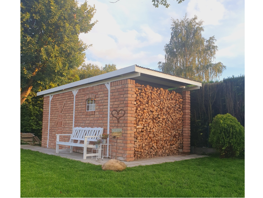 Gartenhaus aus Ziegelsteinen mit Brennholz