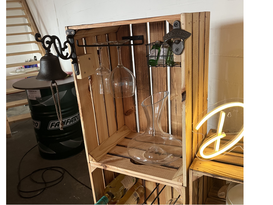 Rustikales Regal aus Holzkisten mit Flaschen und Gläsern