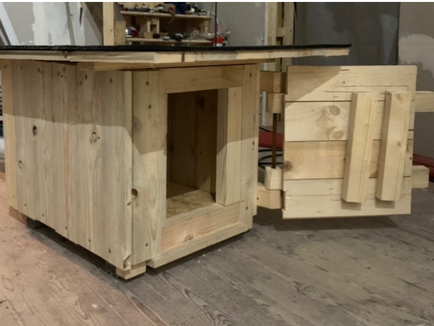 Unfertiges Gartenhaus aus hellem Holz mit offener Tür