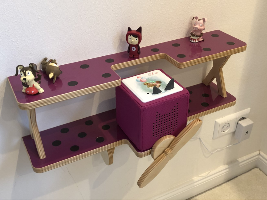 Wandregal in Flugzeugform mit Spielzeug