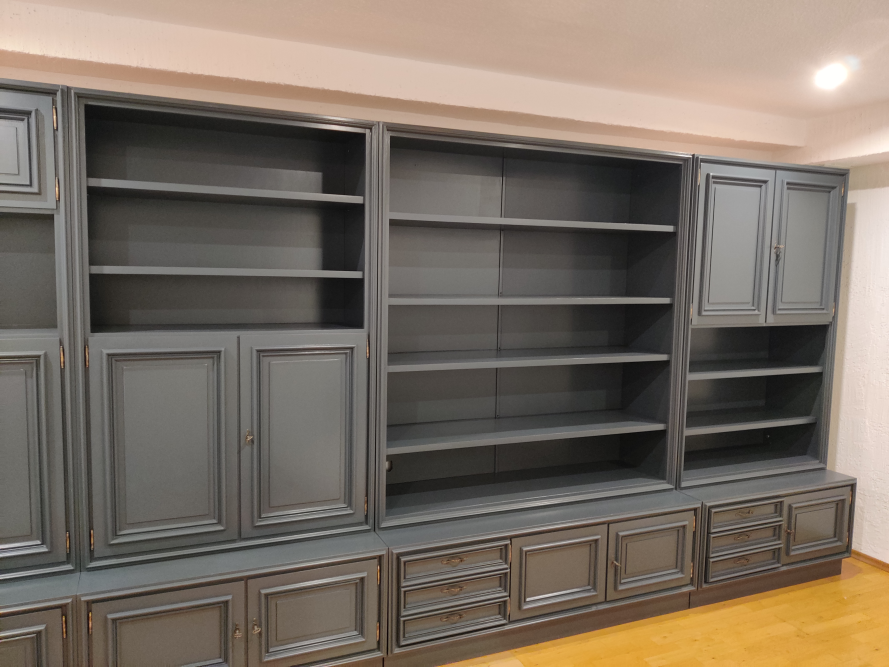 Ein großes, graues Bücherregal mit Schränken und Regalen.