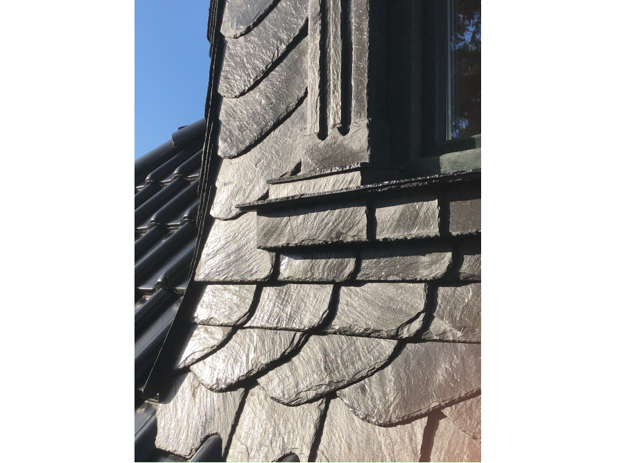 Dunkle Schieferfassade mit Fenster