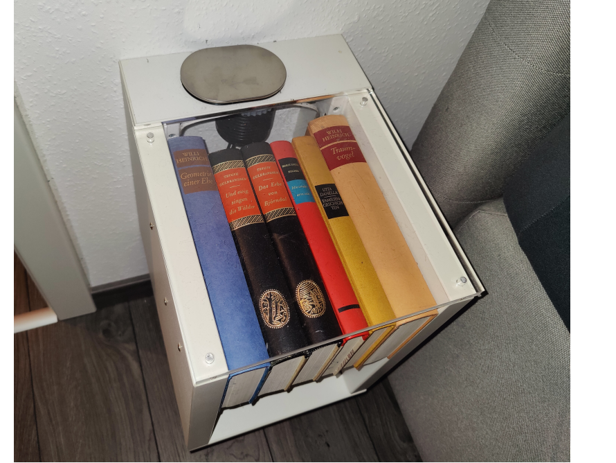 Ein weißes Bücherregal mit einigen Büchern darin