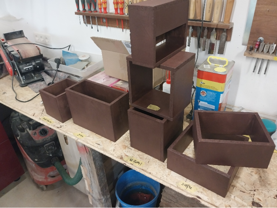 Mehrere dunkel lackierte Holzkästen