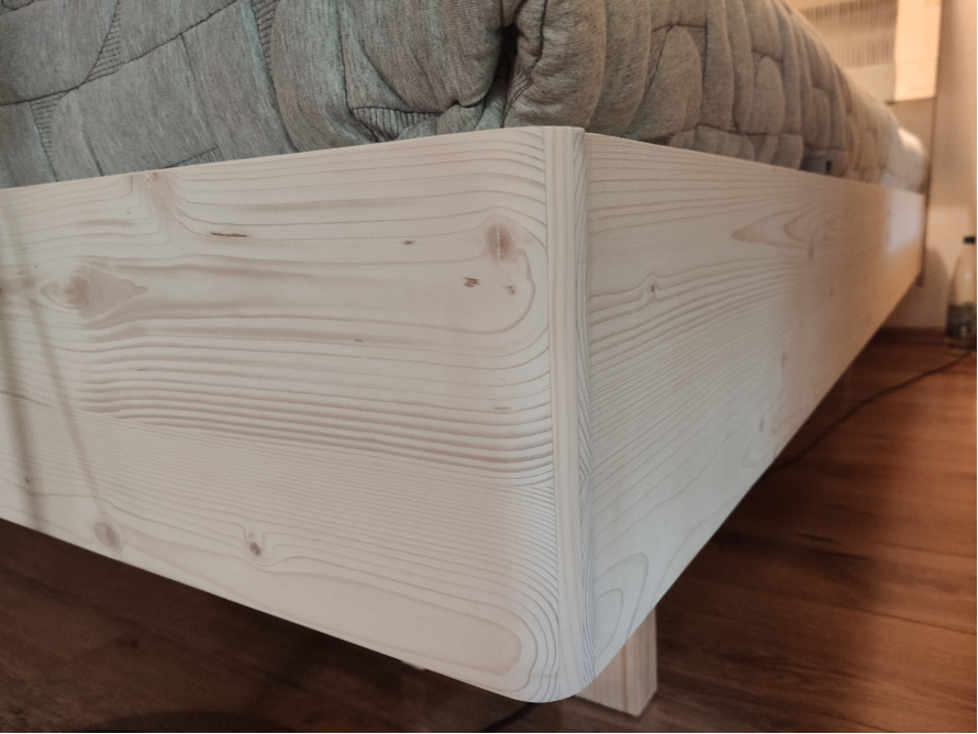 Ecke eines Bettgestells aus hellem Holz