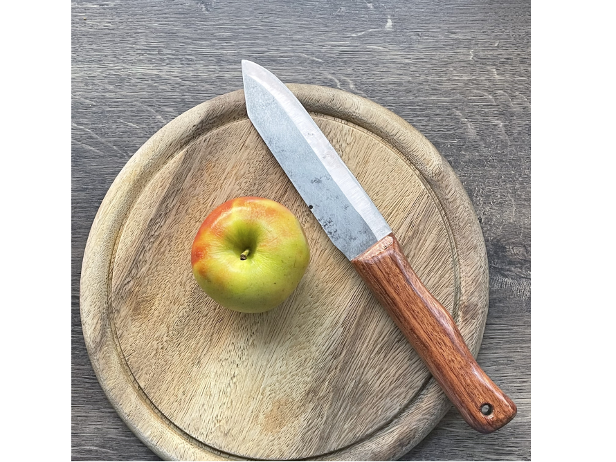 Apfel und Messer auf Holzbrett