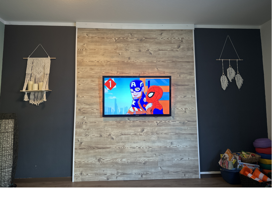 Fernseher an Holzwand mit Deko