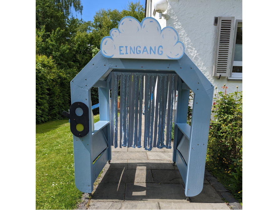 Blauer Holzeingang mit Wimpeln