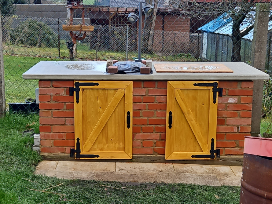 Außenküche aus Backstein mit Holztüren