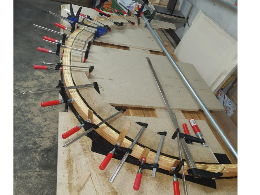 Gebogenes Holz wird mit Schraubzwingen fixiert