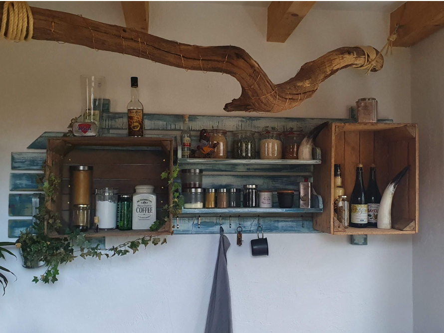 Rustikales Regal mit Gewürzen und Flaschen