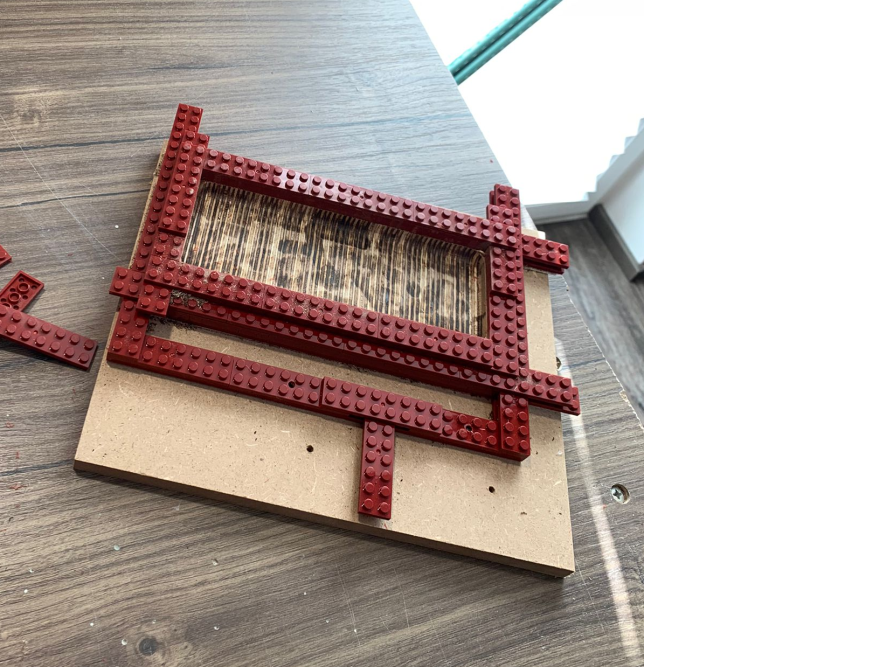 Holzrahmen mit roten Bausteinen