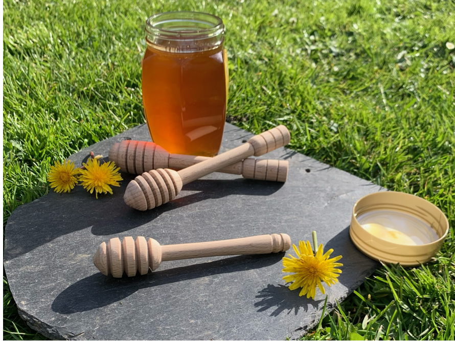 Honigglas mit Honiglöffeln und Löwenzahn