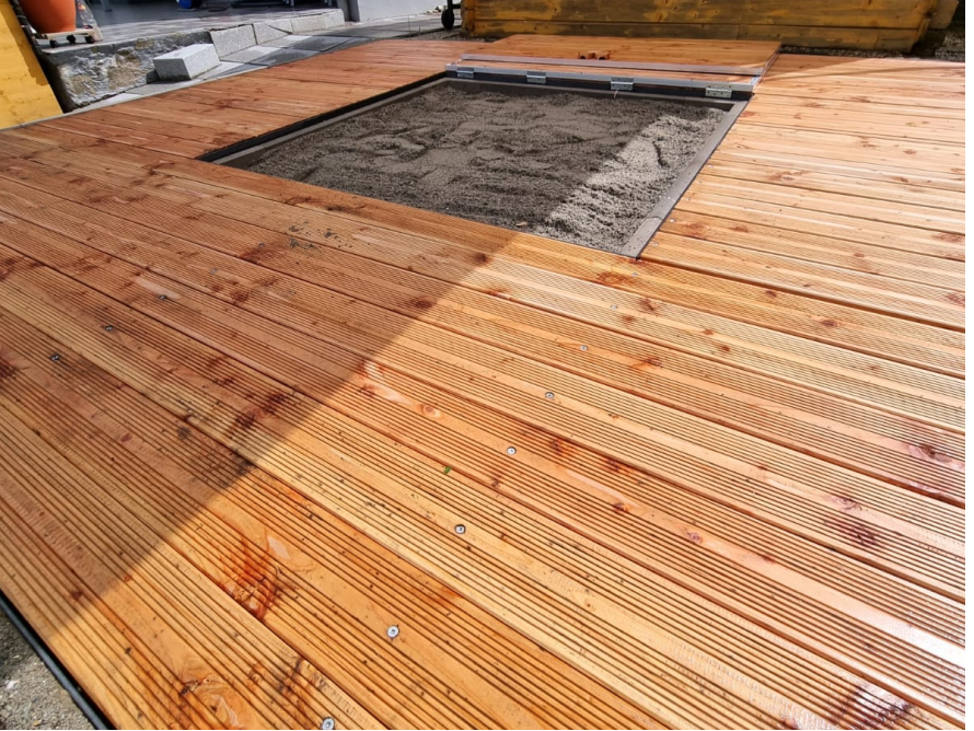 Holzterrasse mit Sandkasten