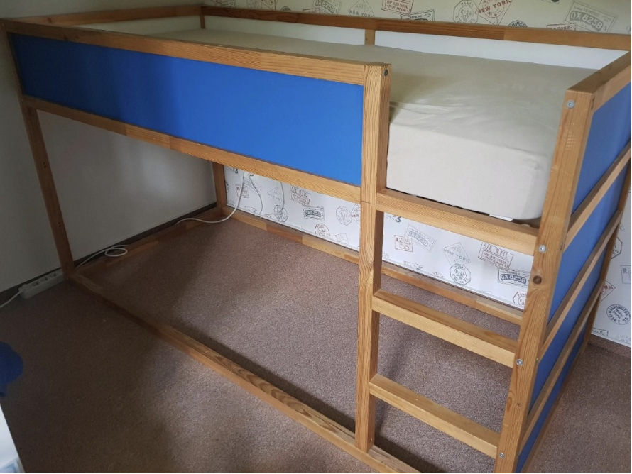 Hochbett aus Holz mit blauer Wand