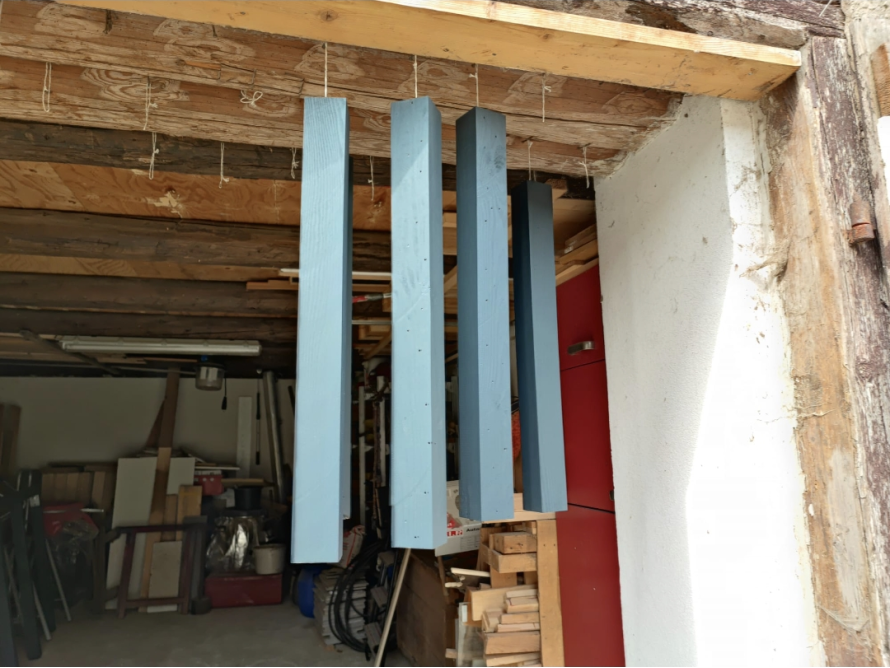 Blau gestrichene Holzbalken hängen zum Trocknen