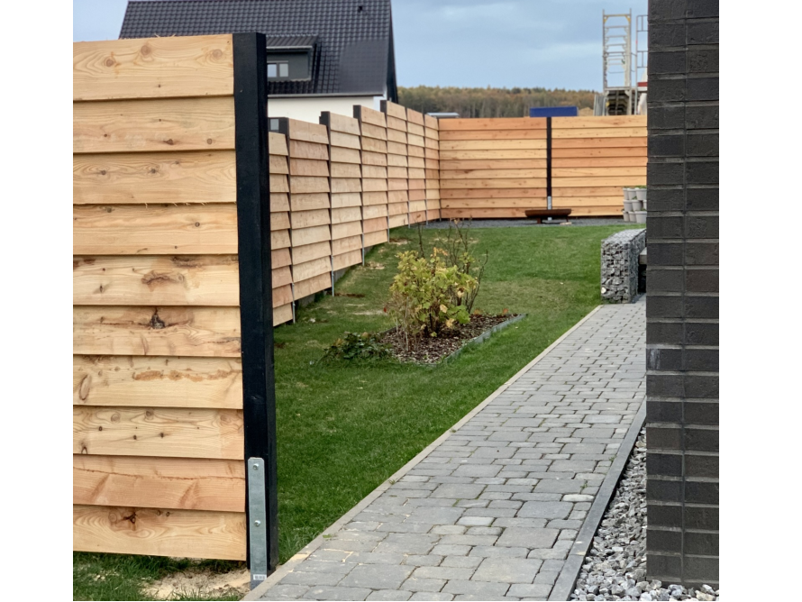 Moderner Holzzaun mit schwarzen Pfosten