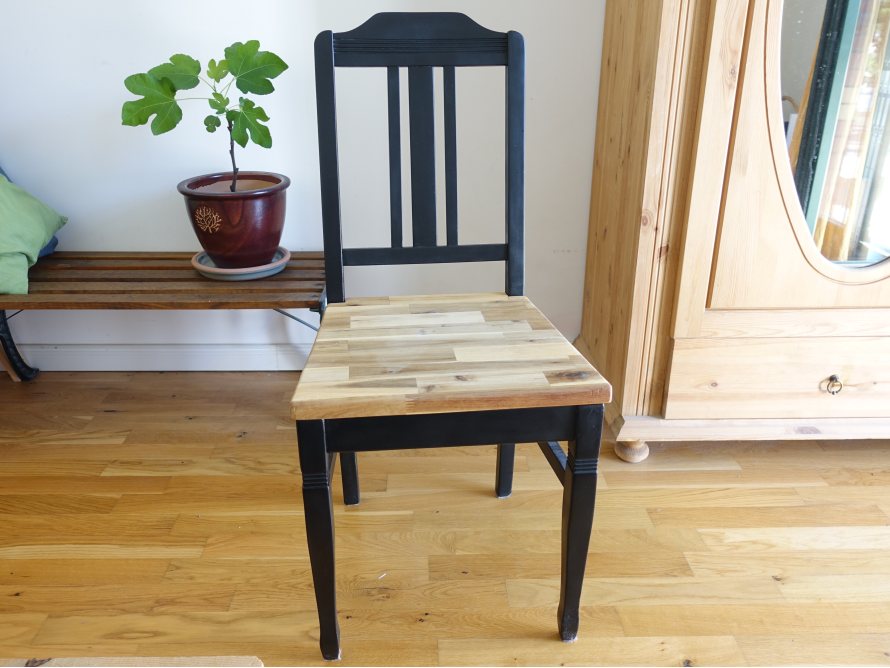 Schwarzer Stuhl mit Holzsitzfläche