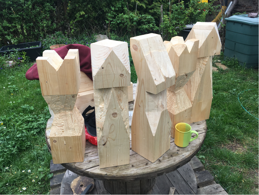 Fünf grob bearbeitete Holzbalken