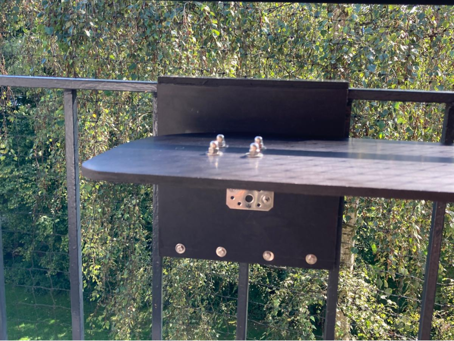 Klapptisch an Balkongeländer montiert