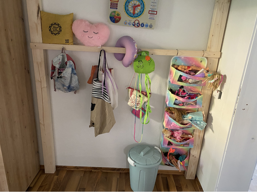 Kleiderstange mit Taschen und Spielzeug