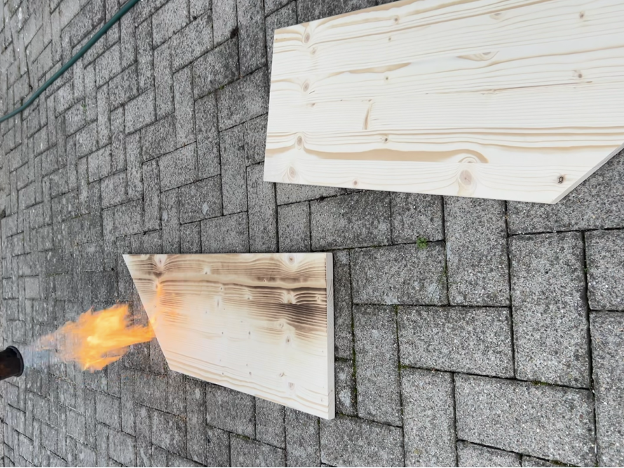 Zwei Holzbretter, eines wird abgeflämmt