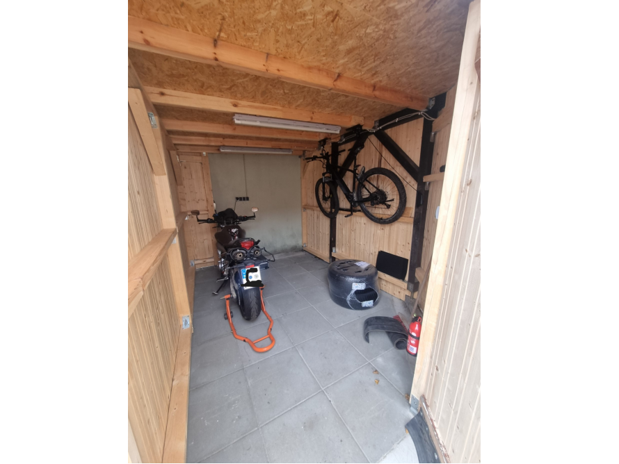 Motorrad und Fahrrad in einem Holzschuppen
