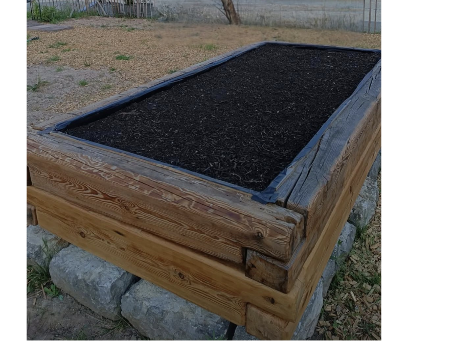 Erhöhtes Gartenbeet aus Holz gefüllt mit Erde