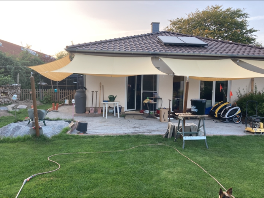 Terrasse mit Sonnensegeln und Gartenwerkzeug