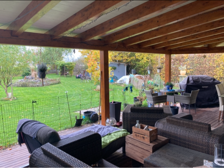 Überdachte Terrasse mit Gartenblick