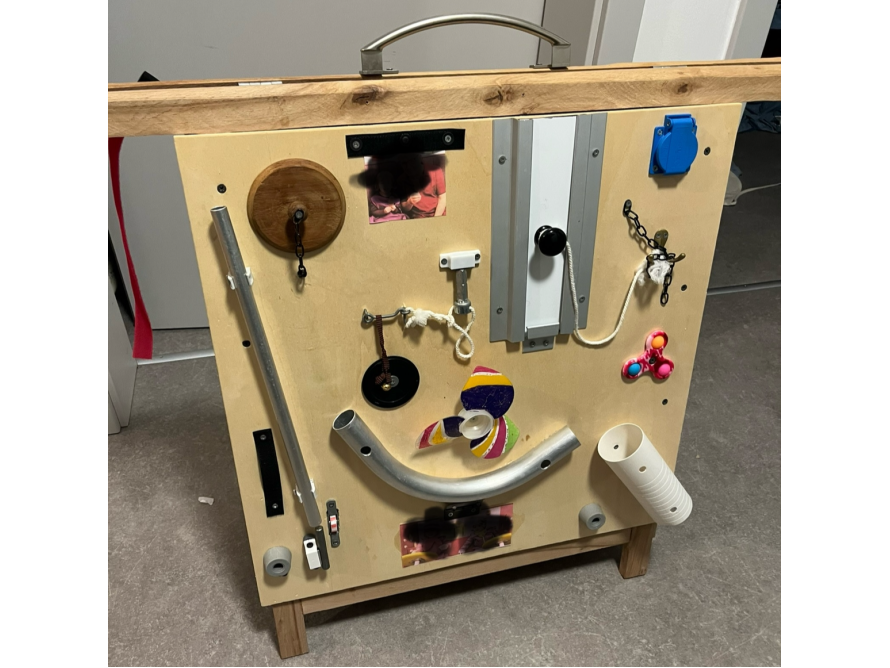 Ein Busyboard aus Holz mit verschiedenen Elementen.