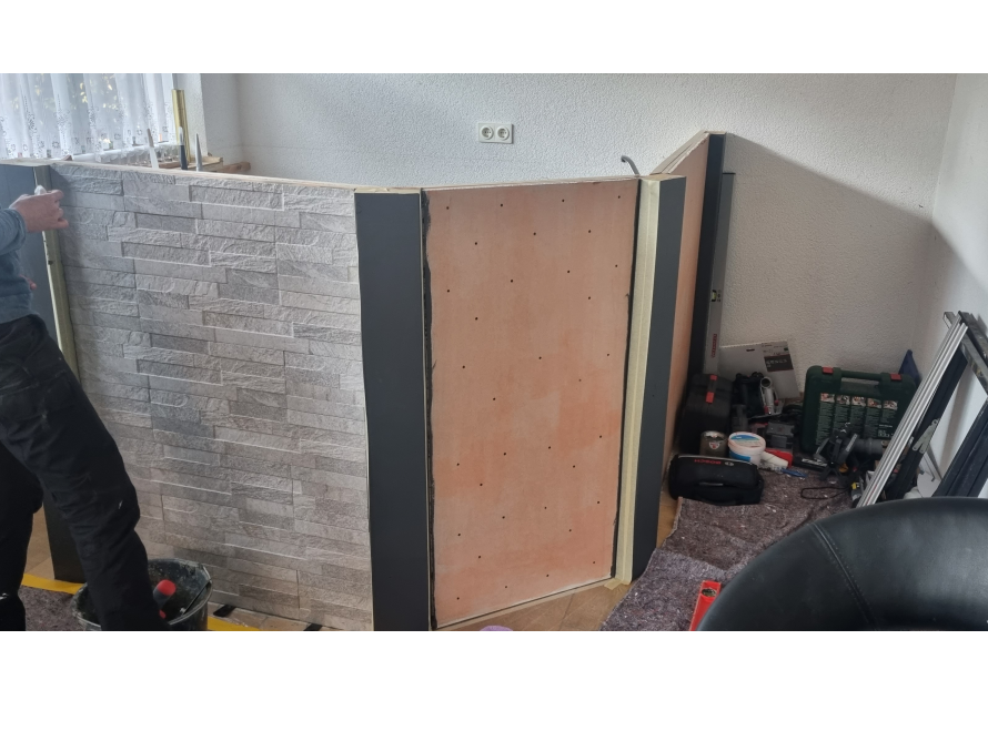 Person baut eine Trennwand aus Rigips