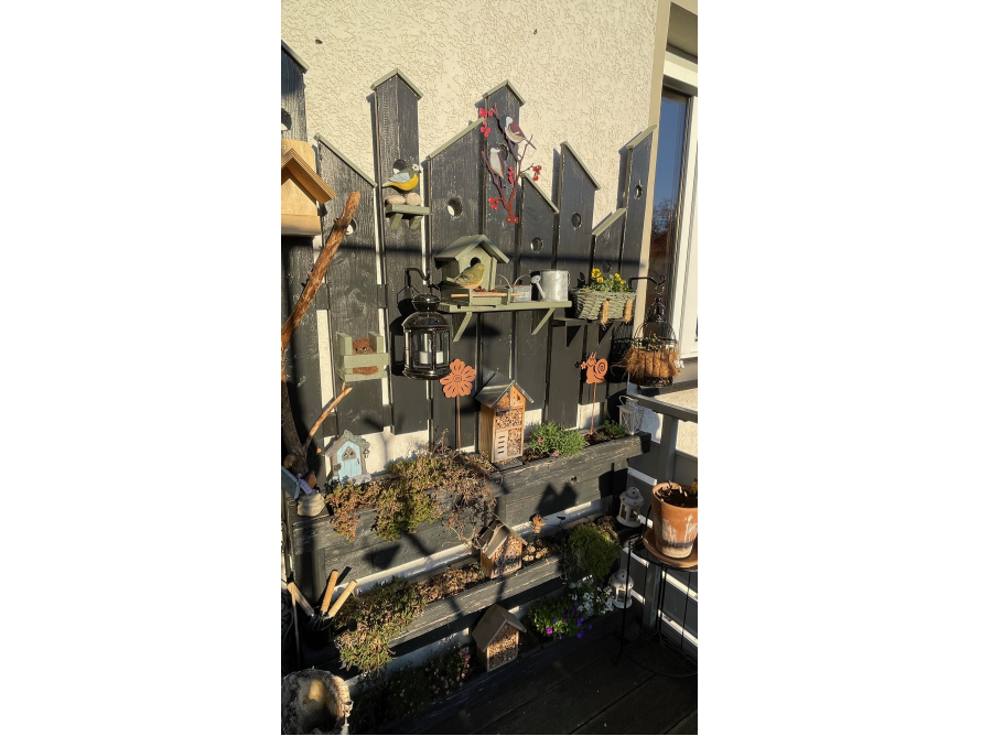 Vogelhäuser an Holzwand auf Balkon