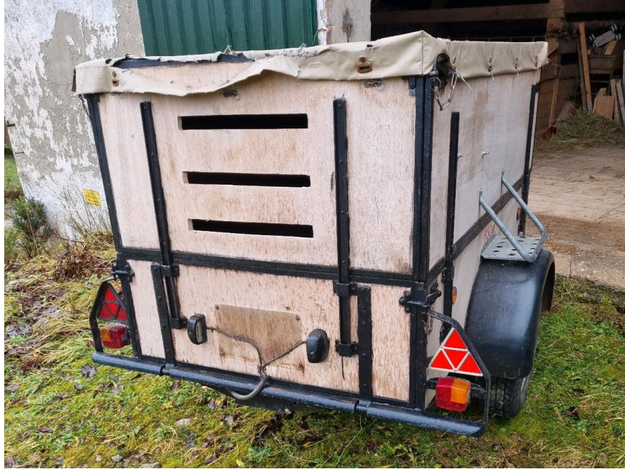 Ein kleiner offener Tieranhänger mit Plane.