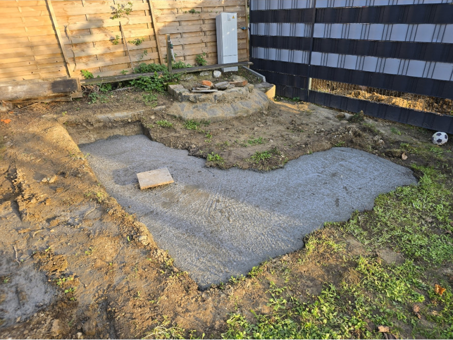 Ein frisch gegossenes Betonfundament im Garten.