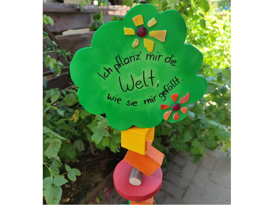Ein grünes Schild in Baumform mit der Aufschrift 'Ich pflanz' mir die Welt...'