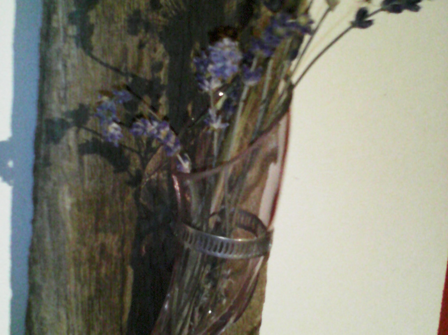 Getrocknete Blumen in Vase an Holzwand