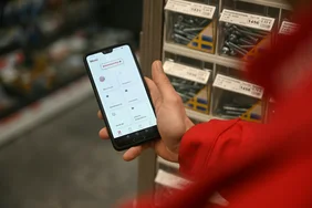 Ein Jahr Mitarbeitenden-App: toom und Flip feiern Geburtstag von toomunity Person hält ein Smartphone in der Hand