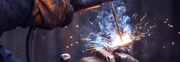 Industriearbeiter schweißt Eisenstücke bei der Arbeit